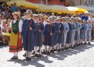 die Schulkinder führen in traditionellen Kostümen historische Tänze auf